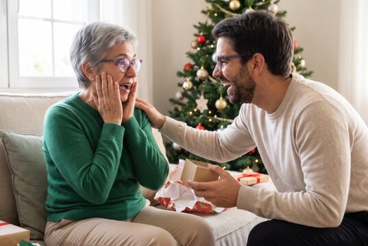 Mother feels surprised and happy opening a christmas gift from her son