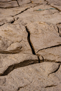 Deep fissures and cracked earth texture on barren parched ground representing desertification and climate change impact on nature