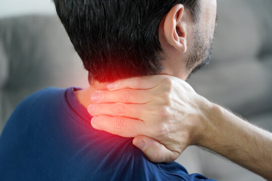 Unrecognizable man massaging back of neck with red highlight showing cervicalgia pain