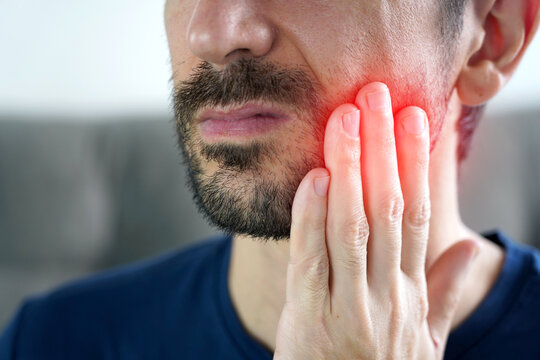 Close up of unrecognizable man with painful face expression suffering from toothache