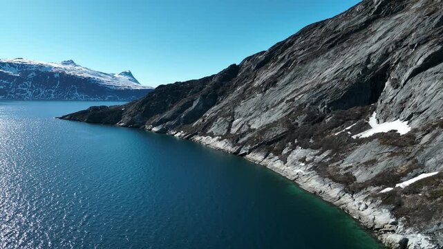 Aerial Drone View of Rocky Fjord Coastline with Snow-Capped Mountains in Greenland Near Nuuk
