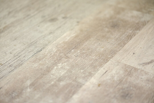 Distressed light wooden parquet flooring texture with realistic grain patterns and visible seams in perspective view