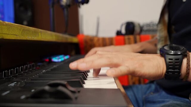 Music producer playing electric piano keyboard