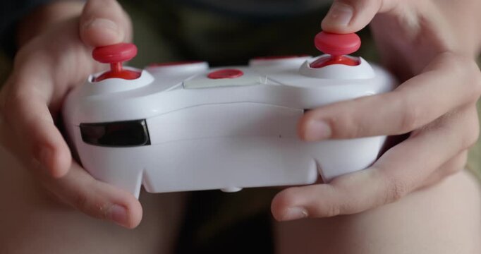 Close-up children's hands use joystick game controller playing video games. 4K 10-bit