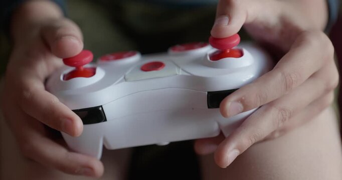 Close-up children's hands use joystick game controller playing video games. 4K 10-bit