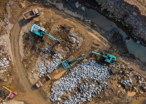 Aerial View of Heavy Machinery work in a Large-Scale Rock Ore Quarry During Morning Viewed from Above in Dawuhan Kulon, Central Java, Indonesia.
