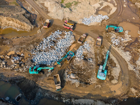 Aerial View of Heavy Machinery work in a Large-Scale Rock Ore Quarry During Morning Viewed from Above in Dawuhan Kulon, Central Java, Indonesia.