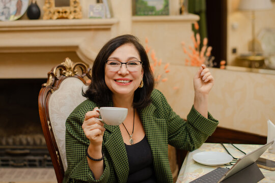 successful woman general manager working on tablet confidently in luxury hotel lounge