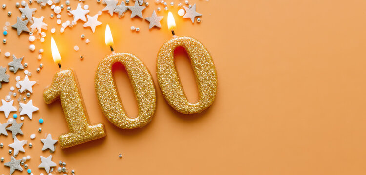 Golden glitter number 100 burning with flames, celebrating a century milestone, anniversary, and birthday on orange background