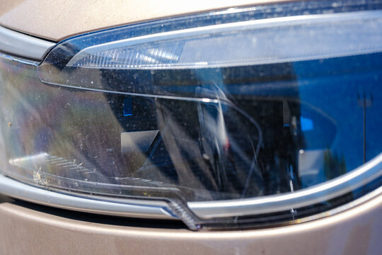 Detailed front LED headlight assembly and daytime running light styling on a bronze Togg T10X smart electric SUV crossover vehicle