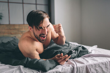 Naked bearded dark-hair man having fun playing video games online using joystick © estradaanton