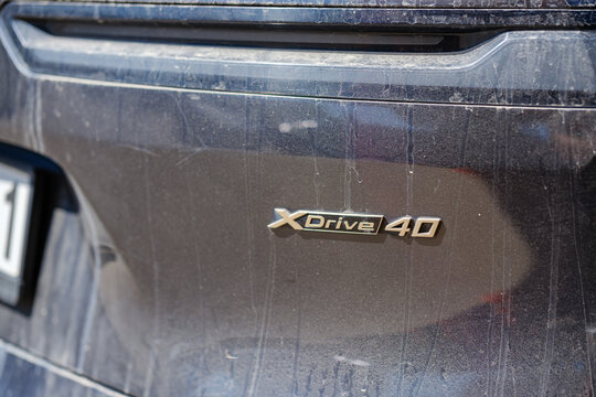 Chrome xDrive 40 emblem badge on dirty dust covered black tailgate of modern BMW all wheel drive luxury automobile