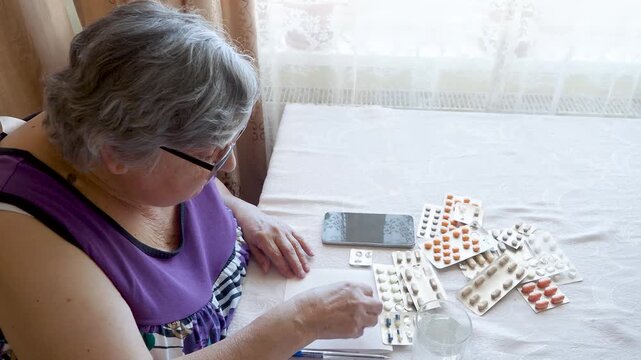 Senior Woman Sorting Pills and Medication Packs at Home