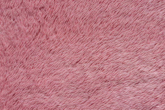 Pink fluffy faux fur fleece fabric texture background 