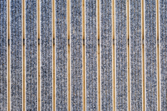 Modern entrance matting system with grey ribbed carpet inserts and aluminum scraper profiles for building doorway