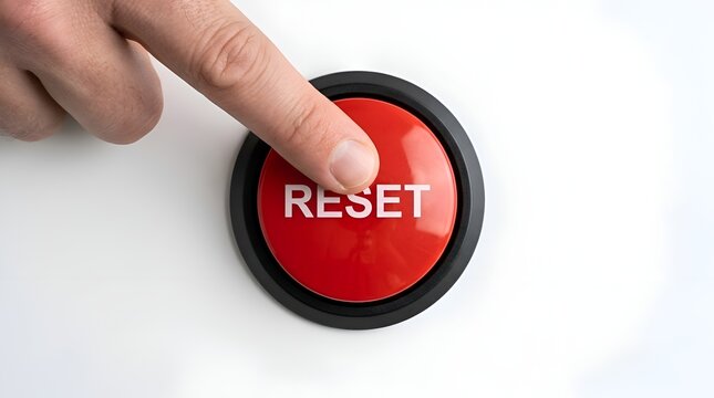 Index finger about to press a large red reset button to restart a system or clear settings on a white background