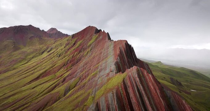Cinematic drone footage, Colourful striped ridge and green Andean slopes of Pallay Punchu Rainbow Mountain near Layo, Canas Province, Cusco, Peru