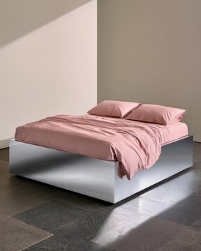Minimal modern bedroom scene with pink bedding on a low mirrored platform for interior design poster and lifestyle background use
