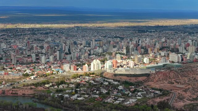 Aerial view of Neuquen City, showing urban buildings and surrounding landscape under a clear sky.