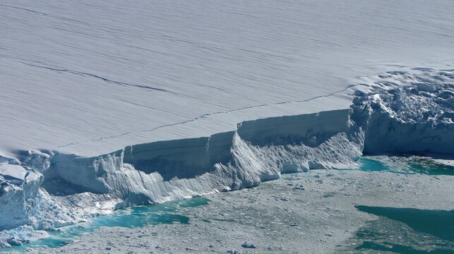 Aerial view of an ice shelf edge meeting the ocean
