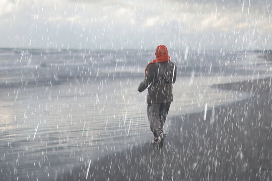 Solitary Figure Walking on Rainy Beach: Embracing Nature's Serenity