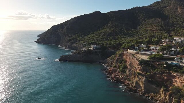 People explore the beautiful coastline of the Costa Blanca, specifically in Albir and Altea, Spain. The sun shines on the Mediterranean Sea and the landscape.