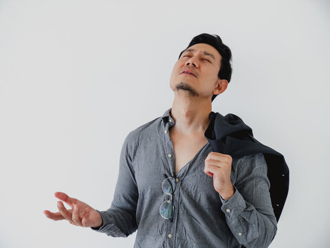 Young Asian man, eyes closed, hand open, deeply relieved or exhausted post-work.