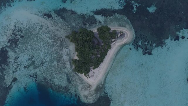 Aerial view of Komodo Island surrounded by turquoise coral reefs and clear blue waters in Komodo, East Nusa Tenggara, Indonesia.