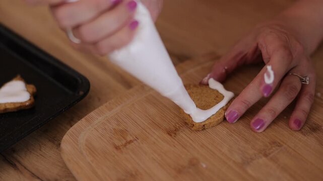 Detail of woman decorating gingerbread Chrsitmas cookies