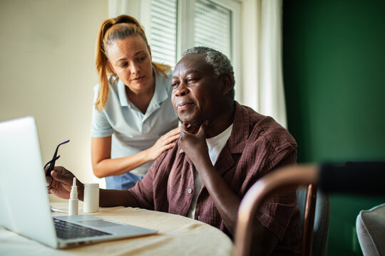 Caregiver helps senior man with throat pain on telehealth