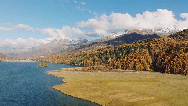 Drone view of a mountain and lake in the Engadin valley, Switzerland. Autumn landscape from the air. Panoramic view. Sunny day in the mountains. 