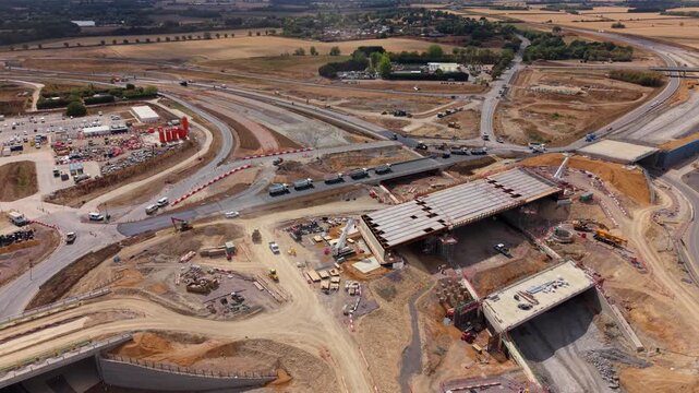 Aerial view of Black Cat Roundabout construction showing ongoing earthworks, bridge structures, and heavy machinery at the site in Chawston, England, United Kingdom.