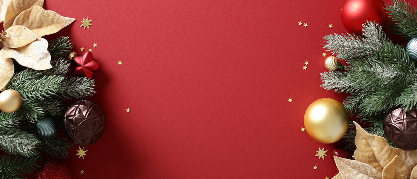 Christmas background with baubles and fir branches on red