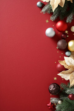 Christmas baubles and fir branches on vertical red background