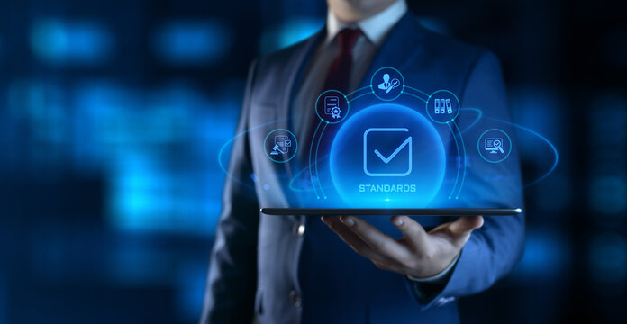 Businessman Holding tablet with Standards Icons on Screen. Quality Management concept