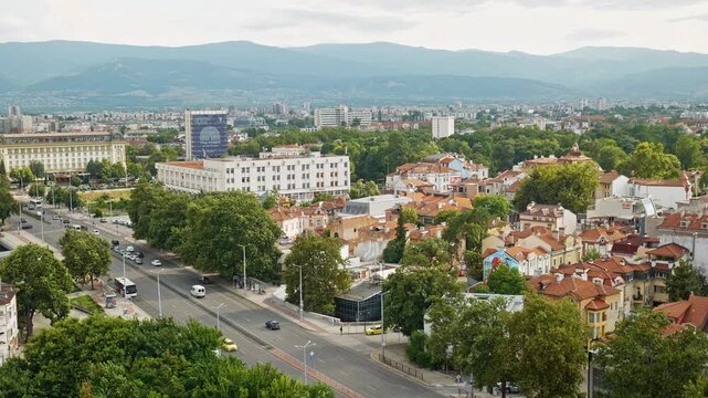 Wide elevated view over central Plovdiv with the Rhodope Mountains visible in the background beyond the city.