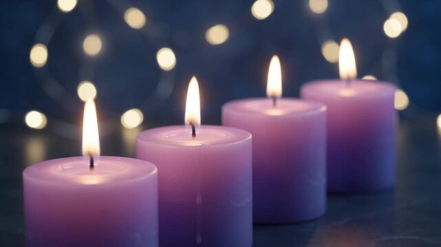 Four glowing purple pillar candles in neat diagonal line with warm flickering flames against dark blue backdrop of soft bokeh fairy lights.
