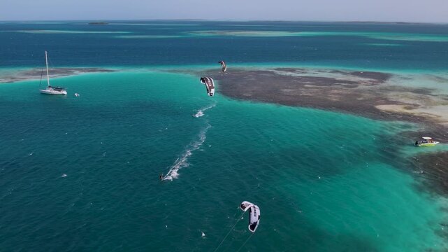 Aerial view of kiteboarders gliding over turquoise water in the Los Roques archipelago, Los Roques, Dependencias Federale, Venezuela.