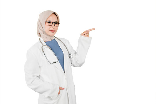 Asian Muslim Female Doctor in Hijab Pointing to the Side with Copy Space