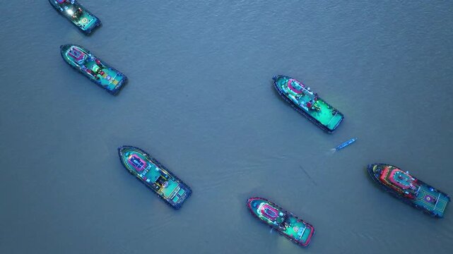 Aerial view of several tugboats navigating the river in Berau Regency, East Kalimantan, Indonesia.