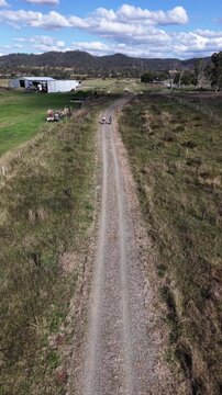 Aerial view of Brisbane Valley Rail Trail with people walking along the gravel path through rural landscape in Esk, Queensland, Australia.