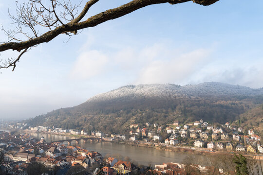 River cityscape with arched bridge and wooded hillside