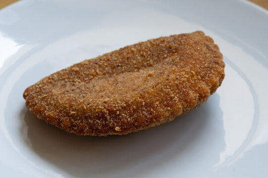 Breaded cutlet on white plate