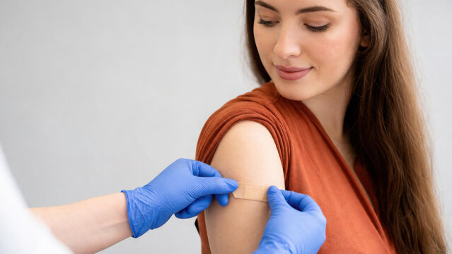 Medical worker applying adhesive bandage on woman arm after vaccination shot generated using ai
