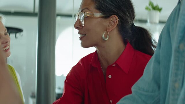 Coworkers celebrate team success in an office huddle, clapping and smiling together to show collaboration, unity, motivation, support, and positive workplace culture.