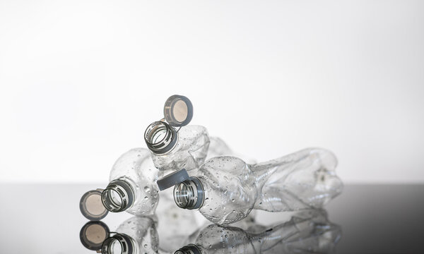 Crushed plastic bottles isolated on white background with reflection