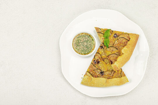 Baked rustic zucchini galette slices on garnished with fresh basil. Homemade savory vegetable tart