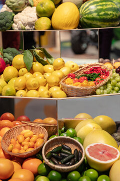Display Of Fresh Produce Including Watermelon Lemons Limes Grapefruit Peppers And Kumquats In Baskets And Piles At A Market