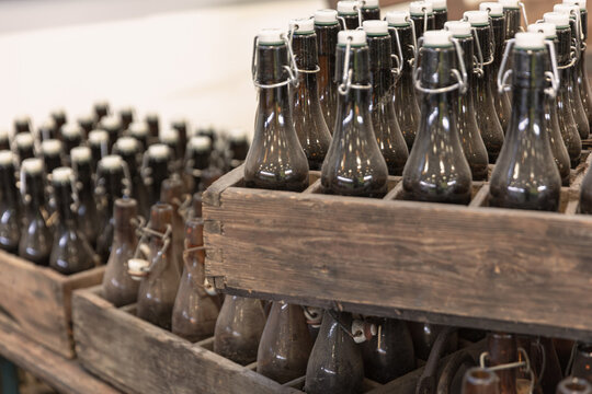 Vintage Glass Bottles With Swing Top Closures In Wooden Crates Ready For Beverage Production Or Display Industrial Design And Rustic Charm