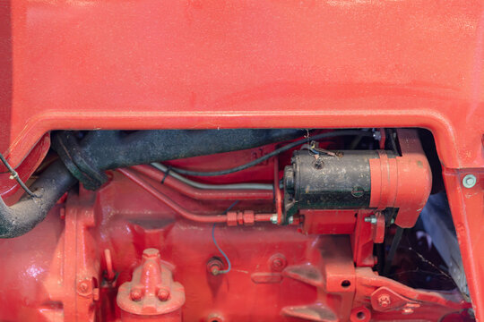 Close-Up Of A Red Tractor Engine With Visible Components Including Pipes Wiring And Mechanical Parts For Automotive Or Agricultural